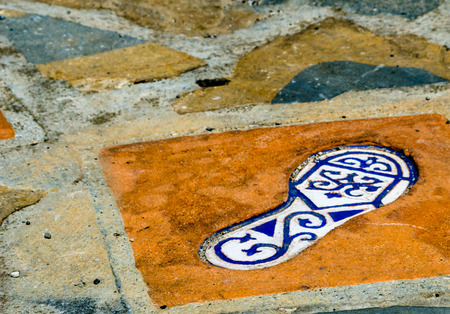 Ceramic tile with an element of reflection of the human foot, a decorative element leading along the tourist trail in a historical Spanish town, tourismの写真素材