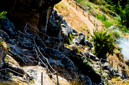 Tourist path in a mountainous Spanish town, a pedestrian trail secured with a rope, active restの写真素材