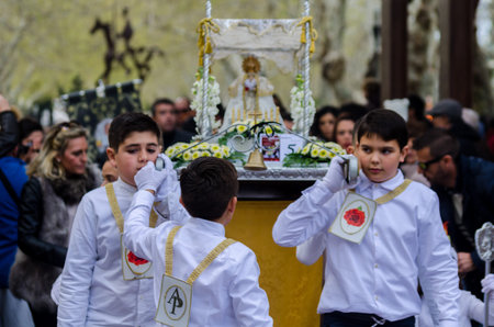 Procession of children starting the holy week.Children in the procession wear platforms with images...