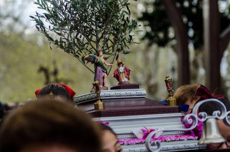 Procession of children starting the holy week.Children in the procession wear platforms with images...
