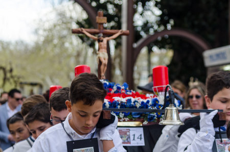Procession of children starting the holy week.Children in the procession wear platforms with images...