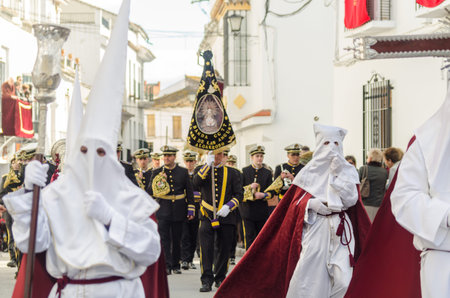 VELEZ-MALAGA, SPAIN - MARCH 25, 2018 People participating in the procession connected in a holy week...