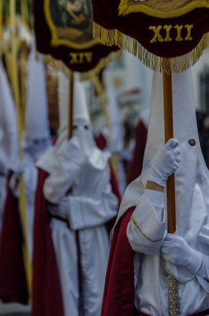 VELEZ-MALAGA, SPAIN - MARCH 25, 2018 People participating in the procession connected in a holy week...