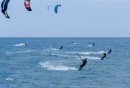MALAGA, SPAIN - MAY 25, 2018 People practicing active sport, wave riding using power kite in a windy bayのeditorial素材
