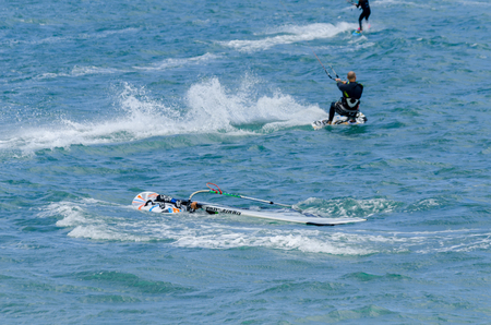 MALAGA, SPAIN - MAY 25, 2018 People practicing active sport, wave riding using power kite in a windy bayのeditorial素材