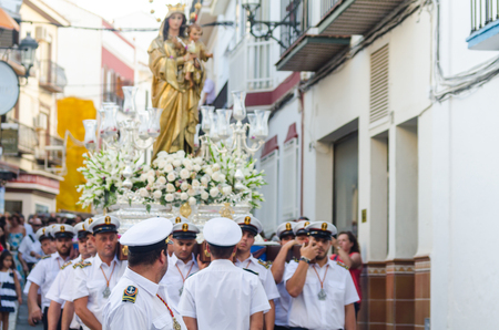 NERJA, SPAIN - JULY 16, 2018 people participating in the celebration of the Catholic ceremony of transferring the holy figure in Spain. The 'Virgen del Carmen' is the patron saint and protector of fishermen and sailorsのeditorial素材