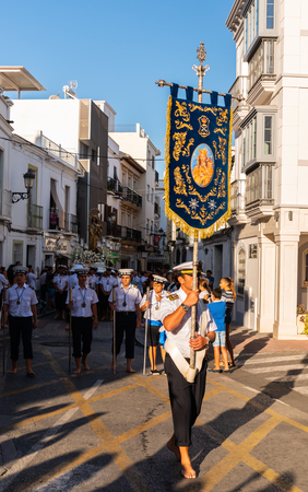 NERJA, SPAIN - JULY 16, 2018 people participating in the celebration of the Catholic ceremony of transferring the holy figure in Spain. The 'Virgen del Carmen' is the patron saint and protector of fishermen and sailorsのeditorial素材