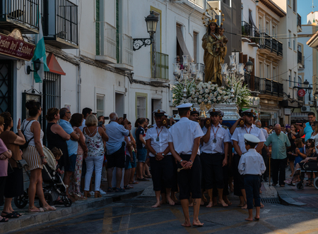 NERJA, SPAIN - JULY 16, 2018 people participating in the celebration of the Catholic ceremony of transferring the holy figure in Spain. The 'Virgen del Carmen' is the patron saint and protector of fishermen and sailorsのeditorial素材