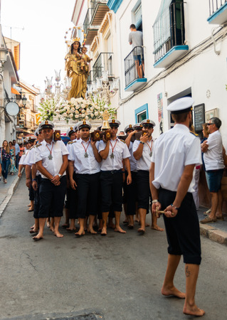 NERJA, SPAIN - JULY 16, 2018 people participating in the celebration of the Catholic ceremony of transferring the holy figure in Spain. The 'Virgen del Carmen' is the patron saint and protector of fishermen and sailorsのeditorial素材