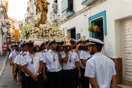 NERJA, SPAIN - JULY 16, 2018 people participating in the celebration of the Catholic ceremony of...