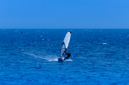 MALAGA, SPAIN - MAY 25, 2018 Windurfer on a board with a sail practicing extreme sport, active restのeditorial素材
