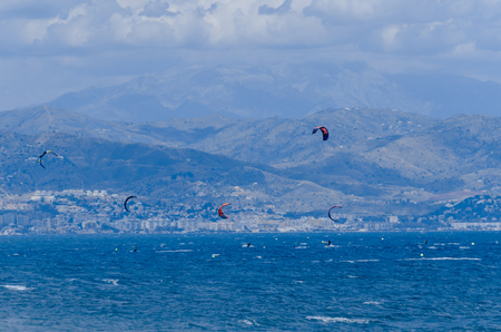 MALAGA, SPAIN - MAY 25, 2018 People practicing active sport, wave riding using power kite in a windy bayのeditorial素材