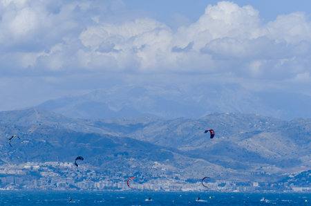 MALAGA, SPAIN - MAY 25, 2018 People practicing active sport, wave riding using power kite in a windy...