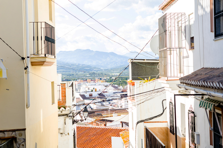 Beautiful and picturesque narrow street with white facades of buildings, Spanish architecture, old townの写真素材