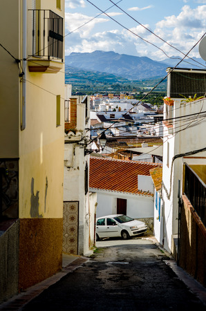 Beautiful and picturesque narrow street with white facades of buildings, Spanish architecture, old townの写真素材