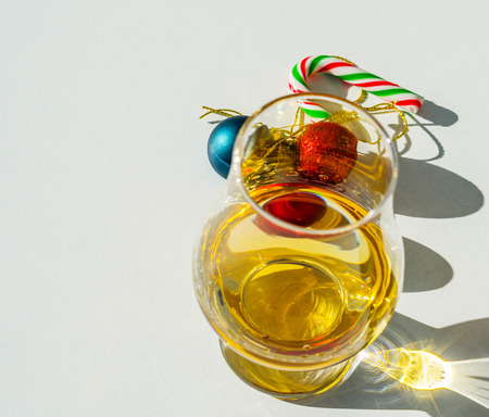 Single malt whiskey glass with candy cane and Christmas balls, the symbol of Christmas holiday, Xmas set decorationの写真素材