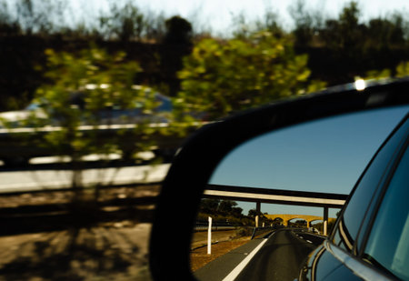 View in the car mirror on fast road in the Spain, beautiful landscape, transportation