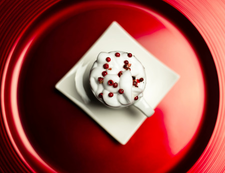 Christmas coffee with whipped cream and a small gift on ceramic saucer, xmasの写真素材