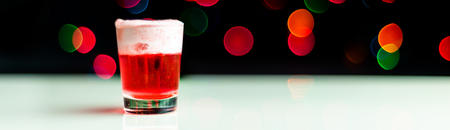 Christmas drink shot in a shot glass on a bokeh background, Christmas decoration on the bar, xmas partyの写真素材