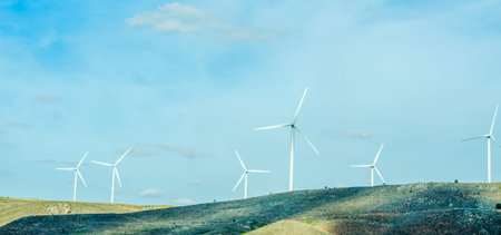 Wind turbines generating electricity on blue sky, alternative energy source, environment