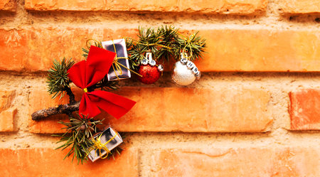 Green Christmas ornament with ball, bow and small gifts  on a wall background, xmas decoration