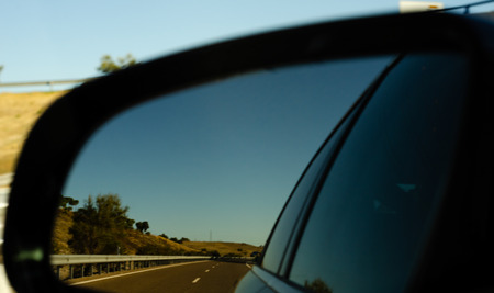 View in the car mirror on fast road in the Spain, beautiful landscape, transportationの写真素材