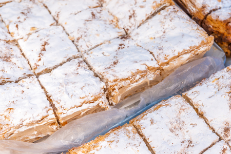 Set of portions of creamy layer cake napoleon on a baking sheet, delicious sweetnessの写真素材