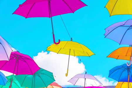 Colourful umbrellas urban street decoration. Hanging colorful umbrellas over blue sky,watercolor