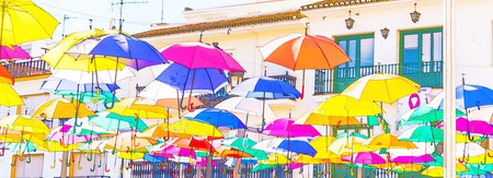 Colourful umbrellas urban street decoration. Hanging colorful umbrellas over blue sky,watercolorの写真素材