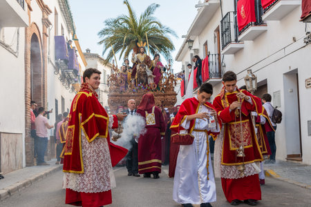 VELEZ-MALAGA, SPAIN - MARCH 25, 2018 People participating in the procession connected in a holy week...