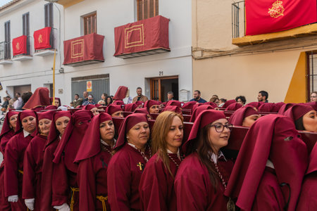 VELEZ-MALAGA, SPAIN - MARCH 25, 2018 People participating in the procession connected in a holy week...