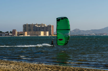 LA MANGA, SPAIN - MARCH 4, 2019 People practicing active sport, wave riding using power kite in a...
