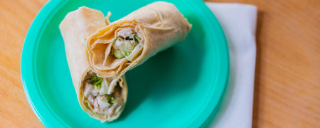 Chicken breast with caesar dressing and lettuce in a gluten-free tortilla wrap, tasty food