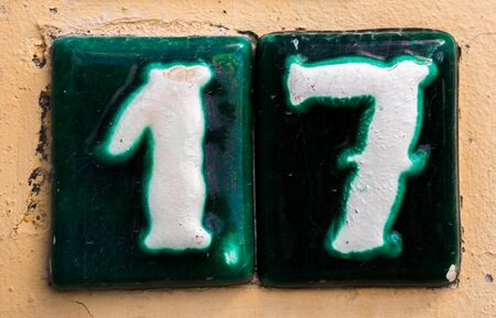 Decorative ceramic house number 17 tile on the wall, characteristic decorative element, numberの写真素材