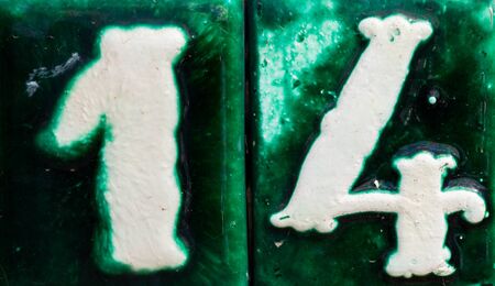 Decorative ceramic house number 14 tile on the wall, characteristic decorative element, numberの写真素材