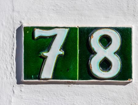 Decorative ceramic house number 78 tile on the wall, characteristic decorative element, numberの写真素材