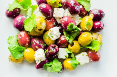 Fresh Greek salad based on green and black olives with pieces of white feta cheese and parsley, traditional Mediterranean cuisineの写真素材