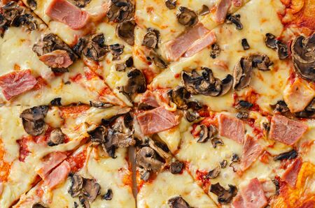 Freshly baked large pizza with ham, mushrooms and mozzarella on a traditional dough, typical Italian dishの写真素材