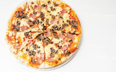 Freshly baked large pizza with ham, mushrooms and mozzarella on a traditional dough, typical Italian dishの写真素材