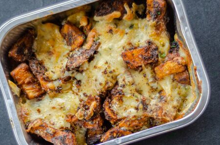 Fried potato fries coated  topped with mature cheddar and Monterey Jack cheeses, jalapeno and bacon sauce, finished with mozzarella and parsley, Dirty Fries dishの写真素材