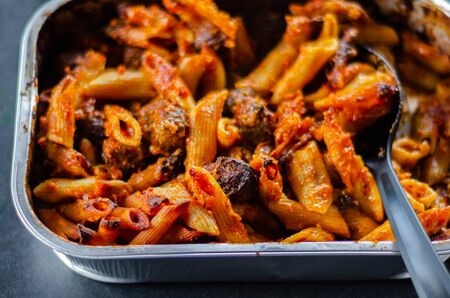 Penne pasta in a tomato and basil sauce with British pork and beef meatballs topped with mature Cheddar cheese, tasty dishの写真素材