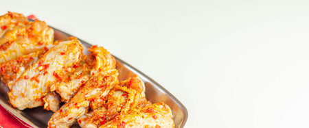 Raw and fresh chicken wings in a siriracha marinade, ready for grillingの写真素材