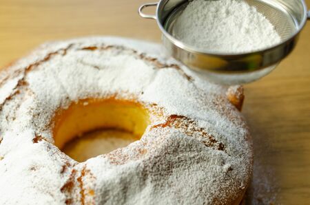 Madeira ring loaf cake decorated with powdered sugar from a strainer, traditional cakeの写真素材