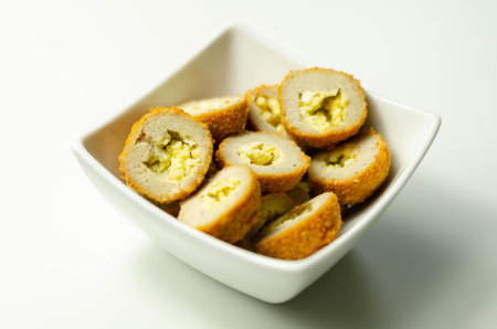 Savory mini scotch eggs in white ceramic bowl, traditional English snack, appetizer