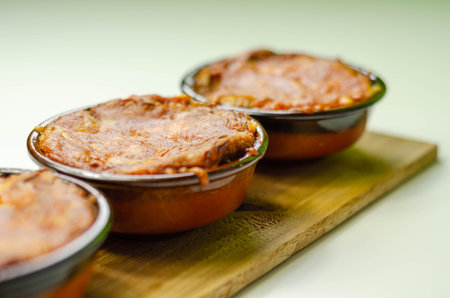 Traditional french onion gratin soup served in a ceramic bowl on a wood, classic dish