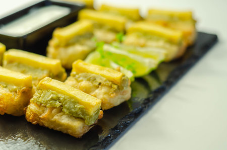 Skinless and boneless battered Alaska Pollock fillet pieces, topped with mushy peas and fried...