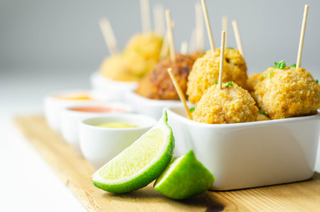 Various mini chicken kievs and sweet potato falafels served with sauces, banquet food
