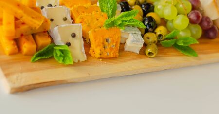British hand-made and selected cheeses from local farms served on a wooden board, a unique setの写真素材