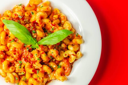Cooked cellentani pasta with cooked chicken breast and peppers in a spicy tomato and jalapeno dressingの写真素材