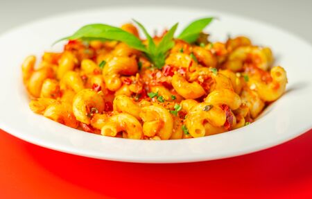 Cooked cellentani pasta with cooked chicken breast and peppers in a spicy tomato and jalapeno dressingの写真素材